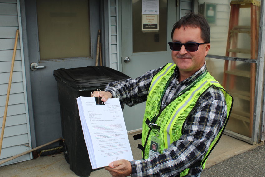 Bill Cutler, county recycling coordinator, shows off the permit application for the Household Hazardous Waste Event. His office had two weeks to put the event together, but they pulled it off.