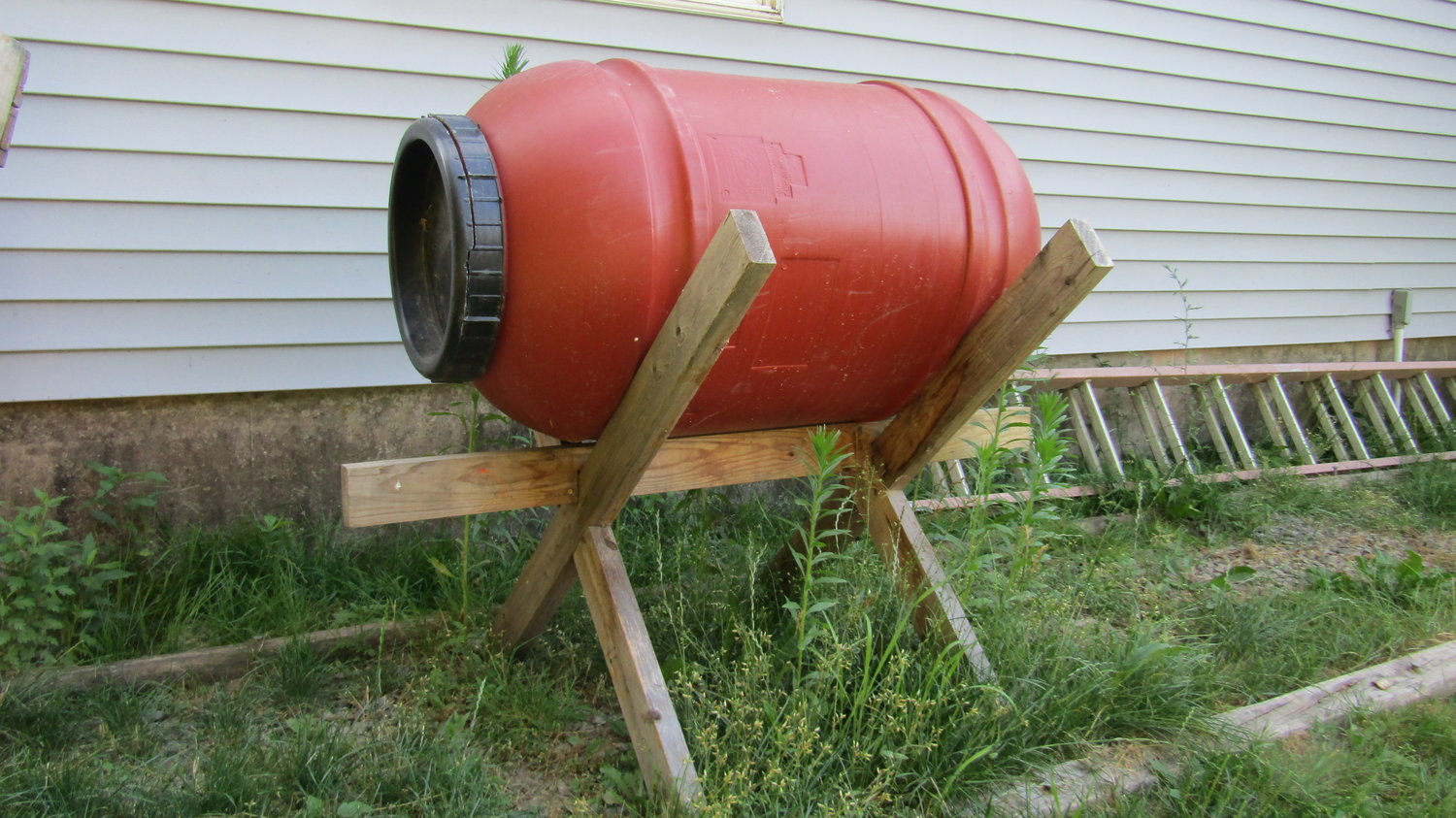 My homemade composting barrel mounted on a stand to turn over the soil inside with ease.