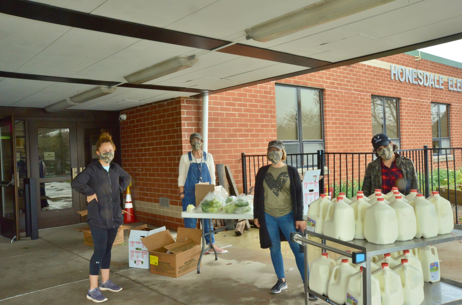 Katie Corcoran, left, Sandy Rickard, Lisa Corcoran and Nicole Curtis help hand out groceries outside of the Lakeside Elementary School.