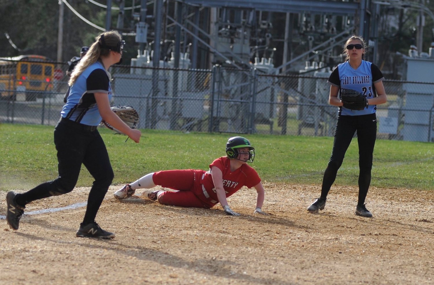 Double-teamed. Liberty’s Katy Decker is safe at third, surrounded by Riley Ernst and Josephine Martinez of Sullivan West.