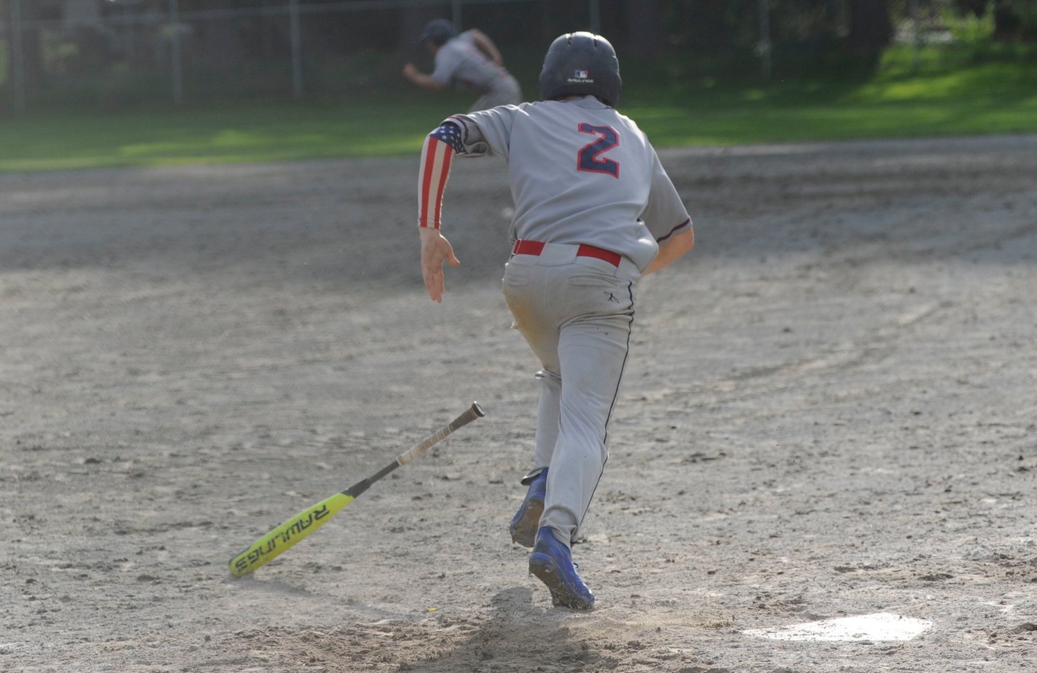 Sprint to first. Tri-Valley’s Austin Hartman legs it to first base while showing his patriotic colors.