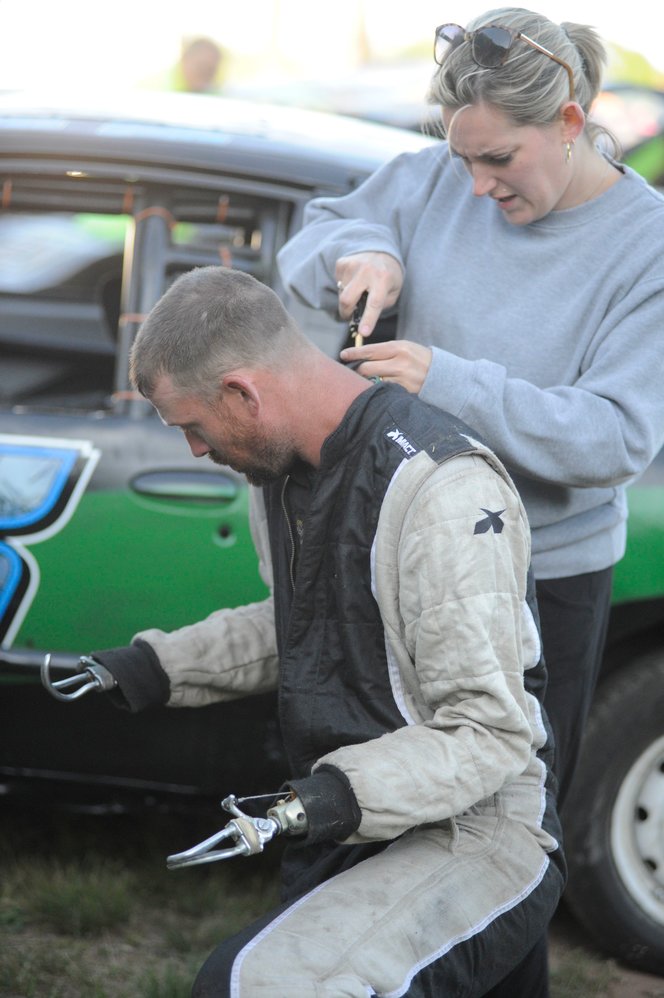Suiting up. Renee Dulin helps her husband Dan suit up before a practice session. He tragically lost both arms when he was electrocuted almost two years ago, but he is now getting back into the racing scene.
