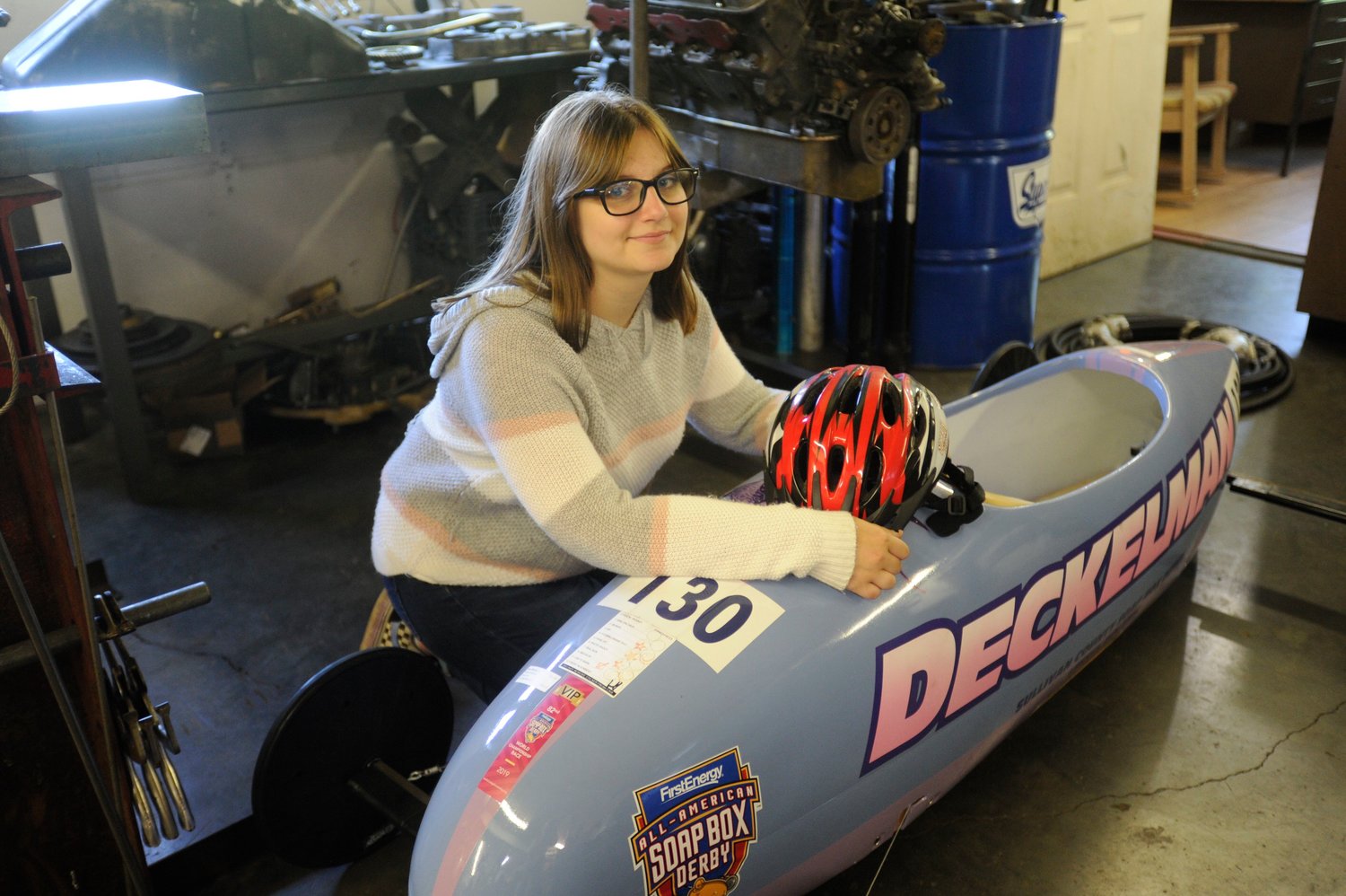 Past glories. Monika Deckelman poses in her dad’s machine shop with her Soap Box Derby racer. Last year, she finished 10th in her division at the Soap Box Derby Nationals in Akron, OH.