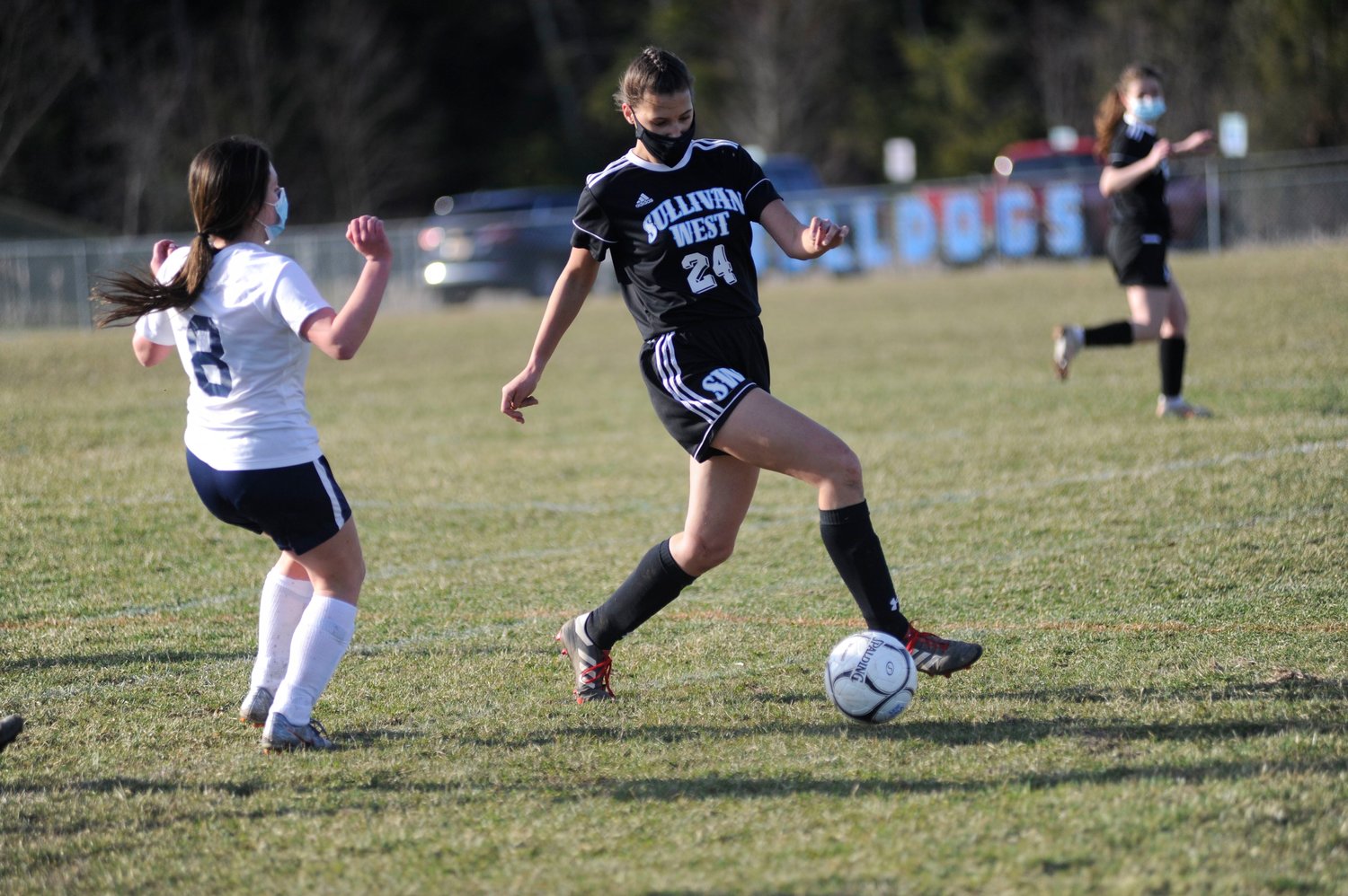 Tiptoe on the grass. Sullivan West’s Anna Bernas gets an edge on the ball as the Lady Bears Clare Verbert closes in.