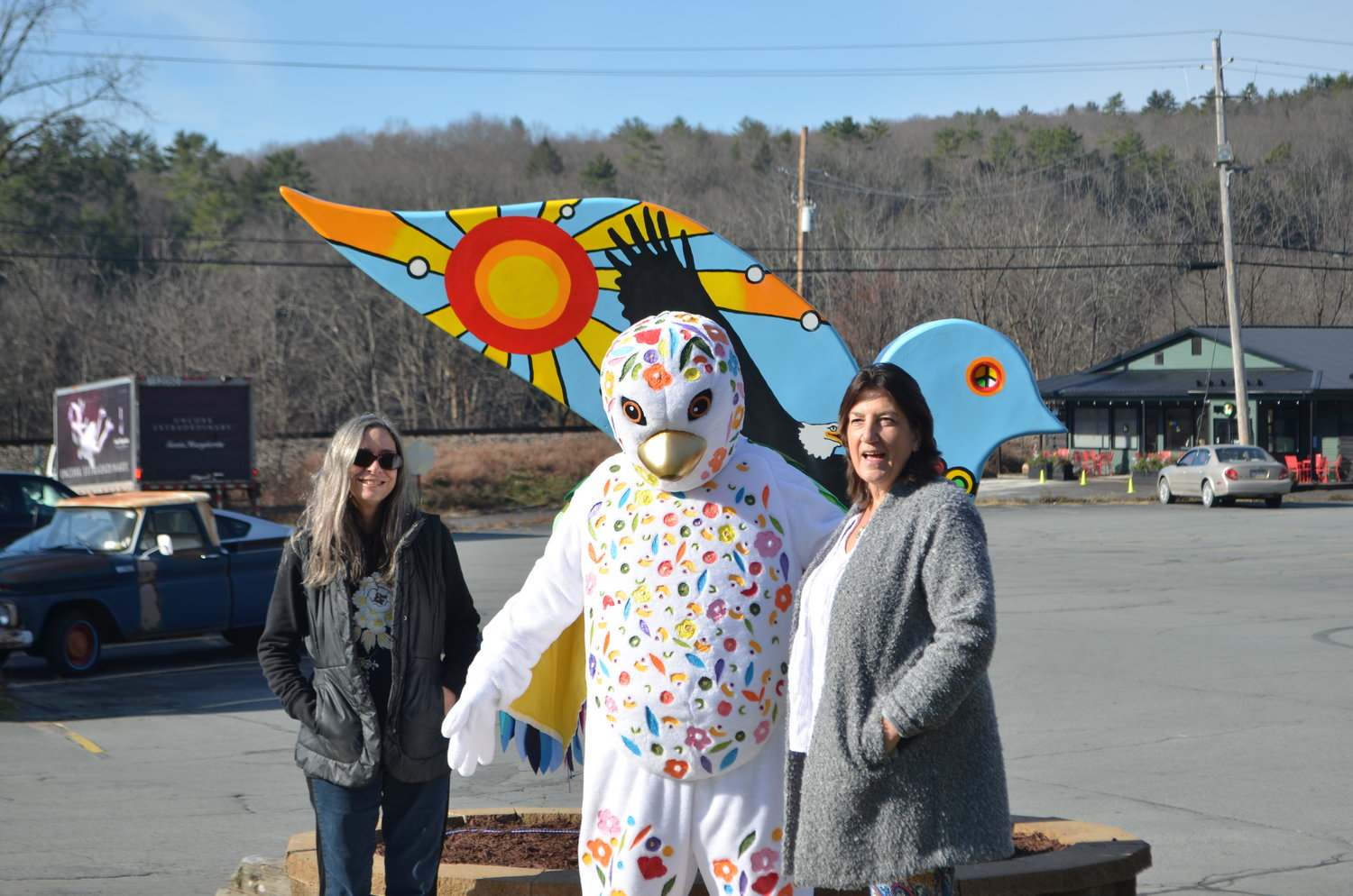 Artist Brandi Merolla, left, stands before the dove with the Sullivan Catskills Visitors Association's dove mascot and Eagle Valley Realty owner Dawn Curreri.
